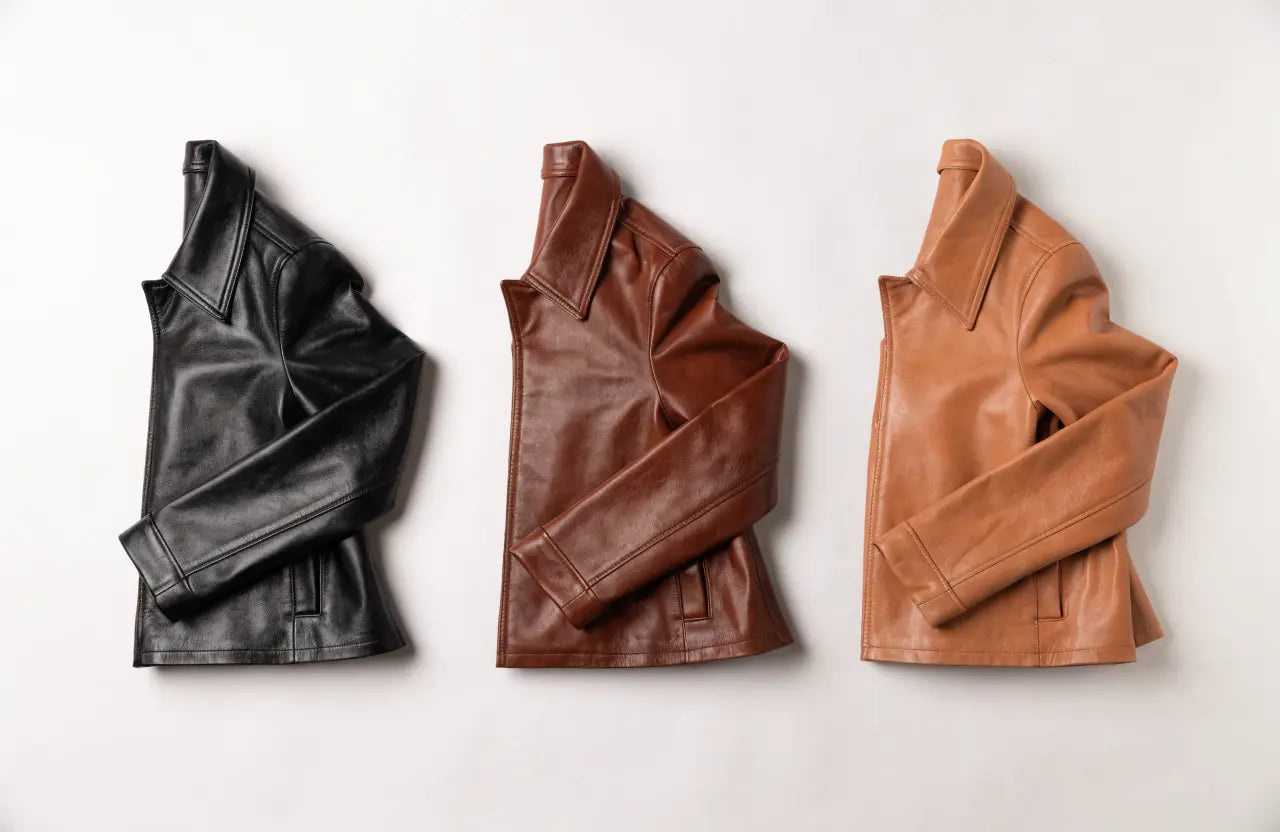 Three leather jackets in black, brown and tan arranged to compare colors